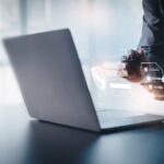 person using laptop on reflective desk